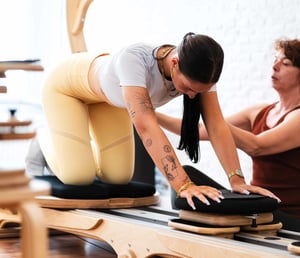 A woman holds her knees to her face in a gyrotonic exercise