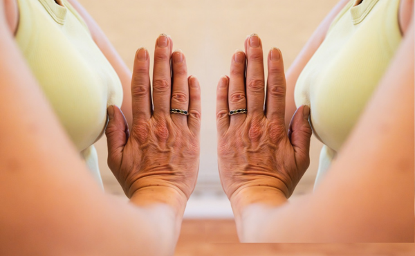 Vrouw houdt haar handen bij elkaar tijdens yoga